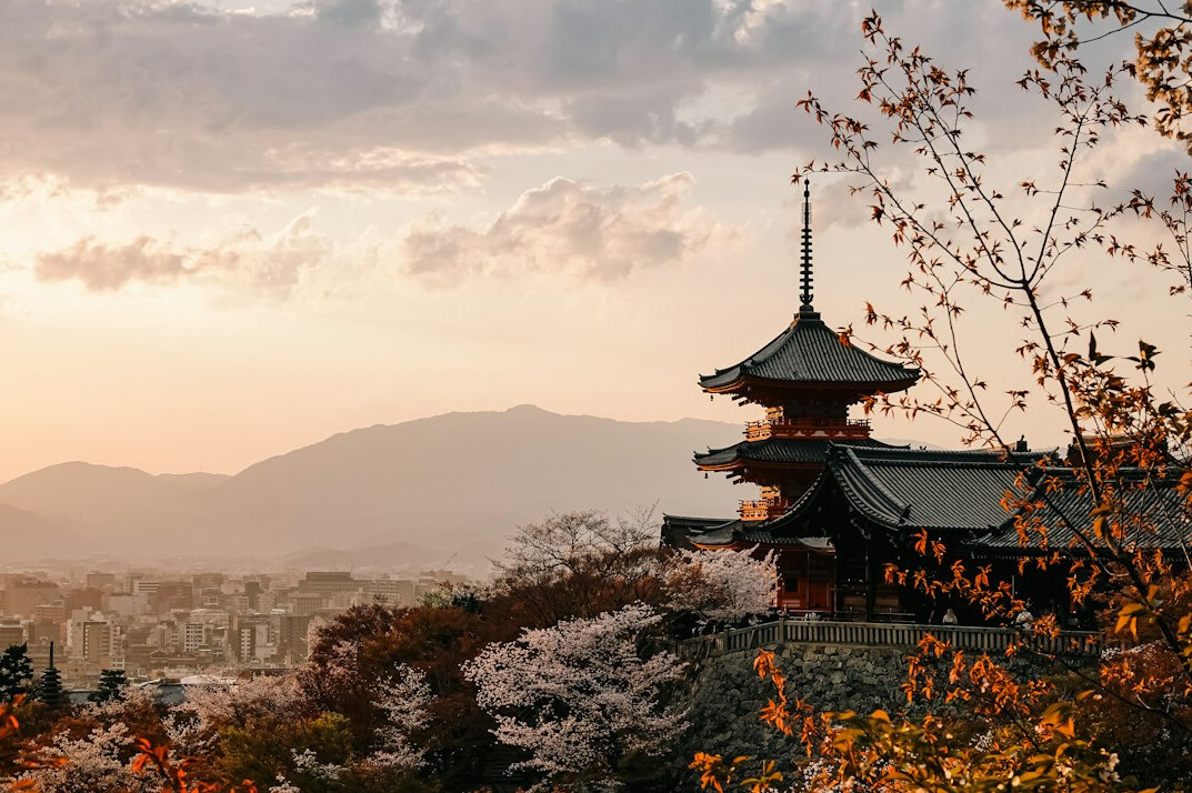 Traditional Japanese temple in Kyoto surrounded by autumn maple trees