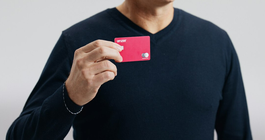 Japanese senior man happily holding a membership card