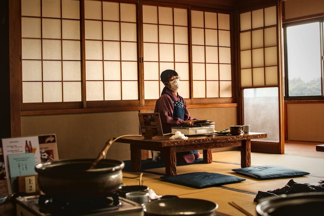 Japanese senior community members sitting together at a table sharing tea and conversation
